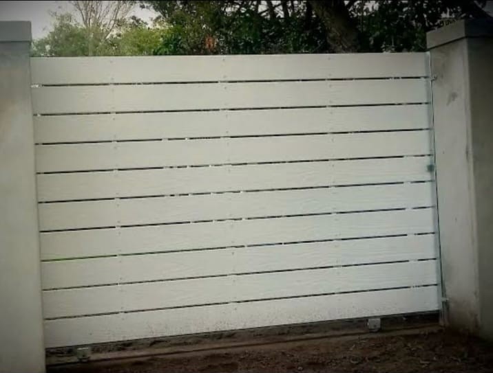 White vertical slat fence panel between concrete pillars