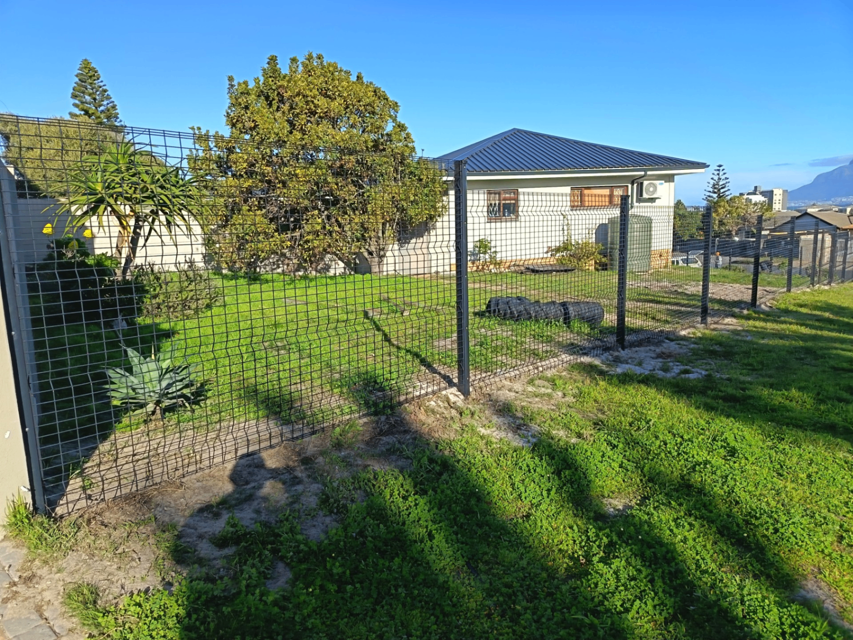Dark grey Clearview mesh fence securing a residential property with mountain views