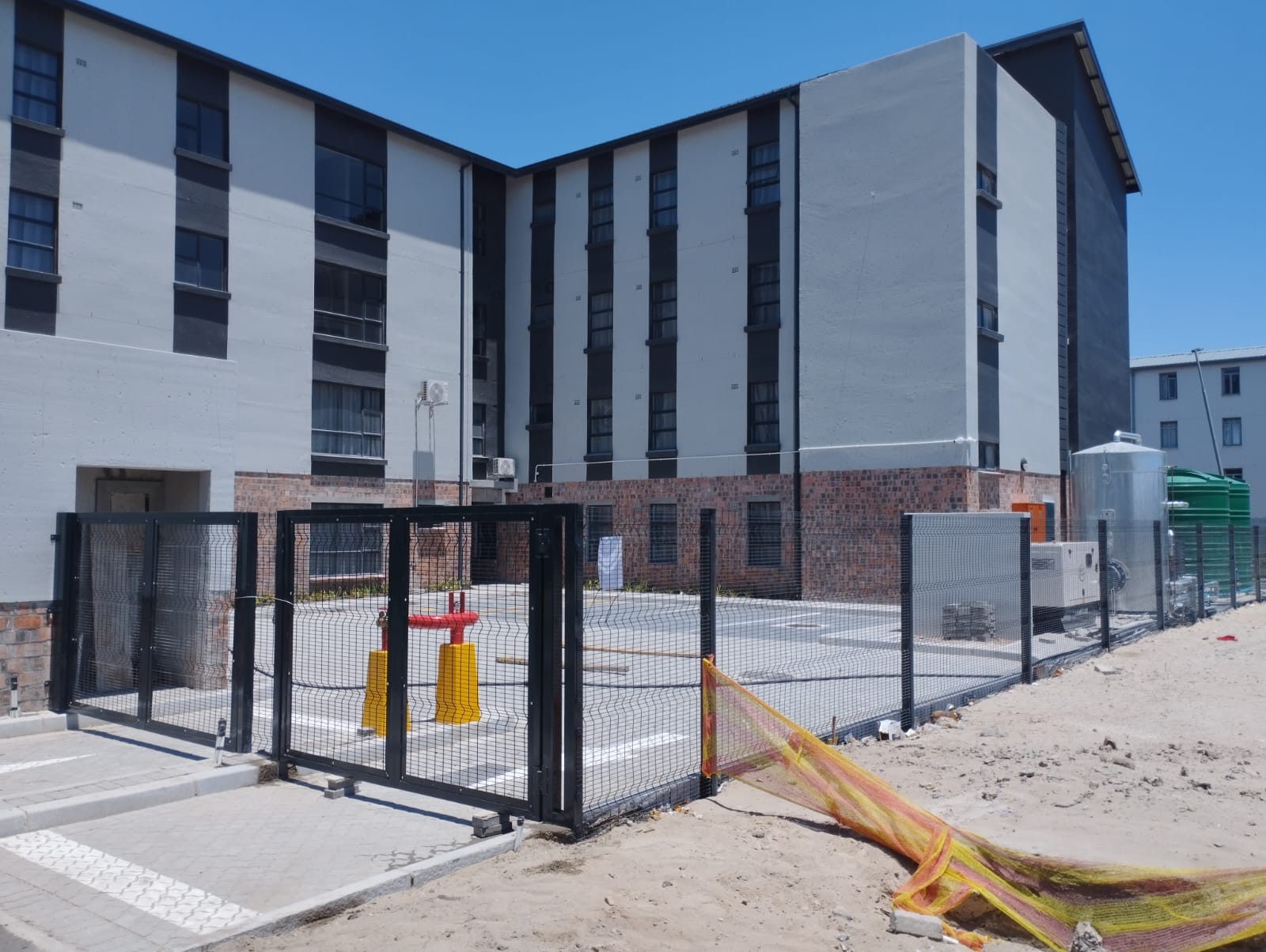 Apartment courtyard enclosed by a black metal fence
